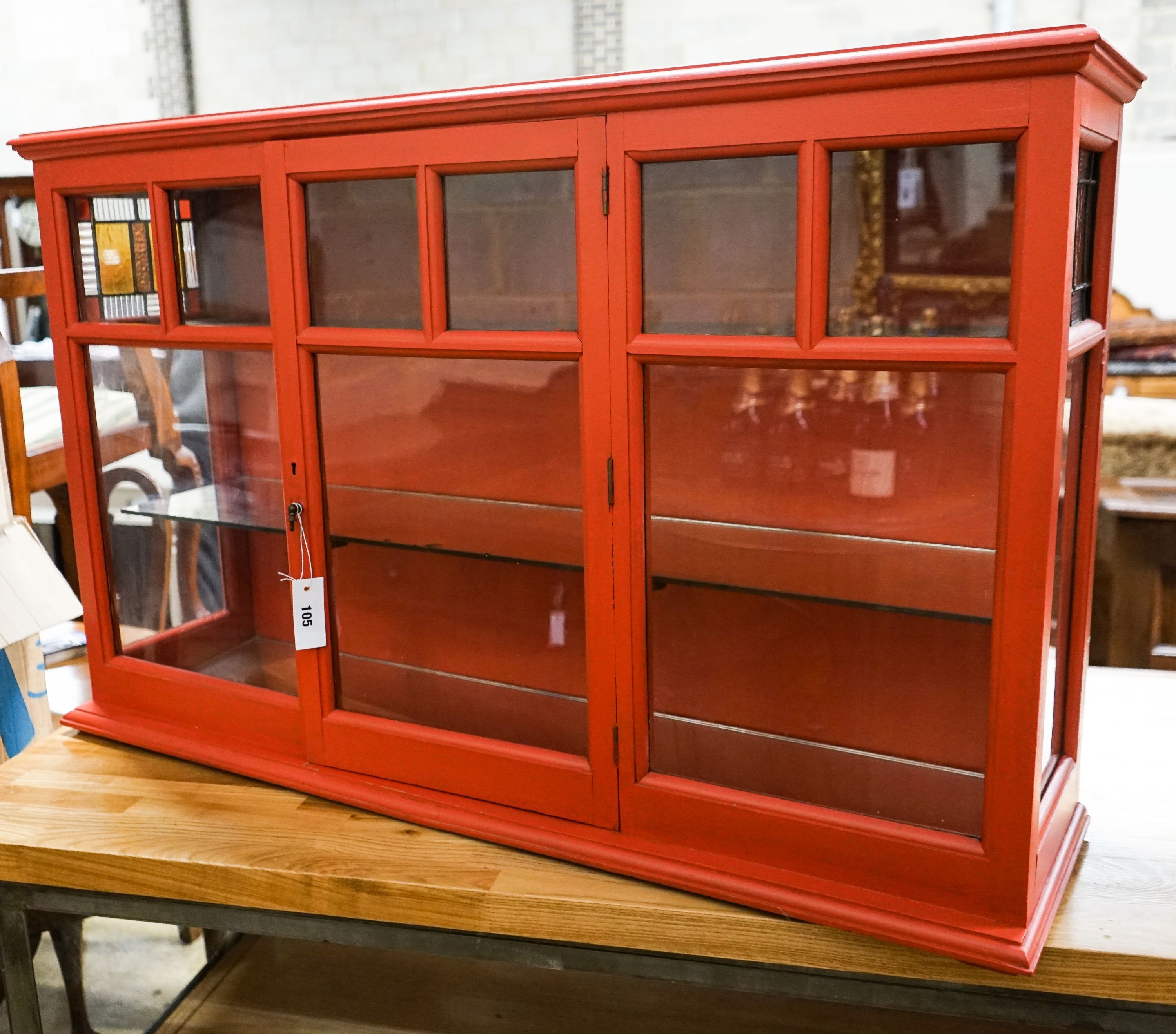 A painted glazed two door wall cabinet with mirrored interior, width 109cm, depth 26cm, height 68cm